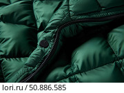 Close up of down jacket button and zipper showing stitching and puffy insulation. Стоковое AI-изображение, AI-художник Иван Рябоконь / Фотобанк Лори
