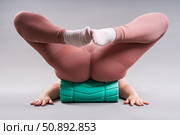 Fat woman in sportswear use myofascial release massage mfr roll on gray background, pelvic floor muscle exercise. Стоковое фото, фотограф Станислав Тарко / Фотобанк Лори