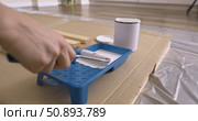 Preparation of paint roller for painting wooden planks, dipping roller in white paint tray. Pouring paint from can into tray close-up of tools, wood board protective film cardboard, renovation process. Стоковое видео, видеограф Сергей Тимофеев / Фотобанк Лори