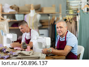 Elderly and young man sew on machine in workshop. Стоковое фото, фотограф Яков Филимонов / Фотобанк Лори