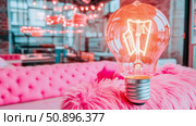 Warm glowing Edison light bulb illuminating a vibrant pink fluffy surface, capturing a creative and cozy ambiance, ideal for innovation concepts or inviting home decor. Стоковое AI-изображение, AI-художник Данила Большаков / Фотобанк Лори