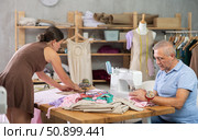 Elderly man sewing, female assistant attaching template to fabric. Стоковое фото, фотограф Яков Филимонов / Фотобанк Лори