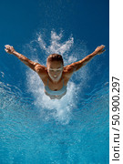 Diver gracefully plunges into clear blue water, showcasing athleticism and precision in motion. Стоковое AI-изображение, AI-художник Гайфуллина Дина / Фотобанк Лори