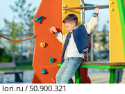 Child in adventure park. Kids climb on high rope trail. Agility and climbing outdoor amusement center for children. Little boy playing outdoors. School yard playground with rope way. Стоковое фото, фотограф Ирина Михайличенко / Фотобанк Лори