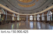 Spacious Islamic library interior featuring ornate Arabic calligraphy decorating ceiling, wooden bookshelves holding historical manuscripts and scholarly volumes. Стоковое AI-видео, аниматор Данил Руденко / Фотобанк Лори