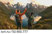 Adventurous couple celebrating summit during scenic mountain hike at sunset. Стоковое AI-видео, аниматор Владимир Федоров / Фотобанк Лори