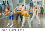 Energetic children practicing modern vigorous movements in dance class. Стоковое фото, фотограф Яков Филимонов / Фотобанк Лори