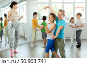 Girl paired up with boy and training to perform slow couple dance, rehearse performance. Стоковое фото, фотограф Яков Филимонов / Фотобанк Лори