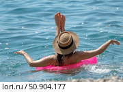 Woman Water Floating: Female floating on pink ring in clear ocean, hat on, relaxing on sunny summer day. Стоковое фото, фотограф svetograph / Фотобанк Лори