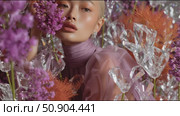 Stunning portrait of a model surrounded by vibrant flowers and crystal decorations in a creative fashion shoot. Стоковое AI-видео, аниматор Сергей Толмачёв / Фотобанк Лори