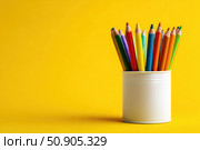 Close-Up of Vibrant Colorful Pencils in a pen holder isolated on yellow background. Banner, copy space. Colourful sharpened colored pencils for art projects, drawing, and creativity. Back to school. Стоковое AI-изображение, AI-художник Марина Демидюк / Фотобанк Лори