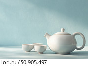 Fresh brewed hot tea set with two cups and a teapot among gray beige wall with copy space. Steaming teacups. Perfect design for tea party, cafe shop, restaurants, afternoon tea. Drink or beverage. Стоковое AI-изображение, AI-художник Марина Демидюк / Фотобанк Лори
