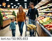 Семья идет вдоль рядов с овощами и фруктами в продуктовом магазине. A family walks along the rows of vegetables and fruits in a grocery store. Стоковое AI-изображение, AI-художник Смирнова Светлана / Фотобанк Лори