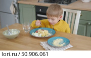 6 years old boy eats pasta with cheese from blue plate. Child is eating spaghetti. Lunch time. Good appetite. Tasty children food. Close-up portrait. Carbs dinner. Fast food. Kid eating with fork. Стоковое видео, видеограф Марина Демидюк / Фотобанк Лори