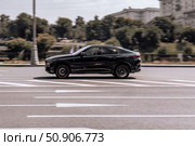 Black color car BMW X6 M50i G06 in fast motion on the street. Редакционное фото, фотограф Константин Григорьев / Фотобанк Лори