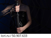 BDSM concept. A woman in a leather corset holds a black lash with a long fringe. Role-playing games for adults. Close-up of sex toys for domination. The whip in female hands. Стоковое фото, фотограф Михаил Решетников / Фотобанк Лори