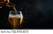 Celebrating Brew: Pouring Alcoholic Beverage into a Glass with Amber Liquid and Effervescent Bubbles. Стоковое AI-изображение, AI-художник Данила Большаков / Фотобанк Лори