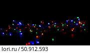 Messy jumble of multicolor christmas lights on black background, festive holiday decoration with red, green, and blue colors overlay. Стоковое AI-изображение, AI-художник Павел Муравьев / Фотобанк Лори
