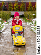 Winter Joyride: Toddler's Happy Moments on Toy Vehicle, Creating a Festive winter card,  celebrating winter fun. Стоковое фото, фотограф Данила Большаков / Фотобанк Лори