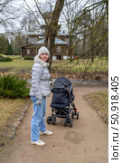 A woman with a baby stroller in a park next to an old style house. Музей-усадьба Ильи Ефимовича Репина "Здравнёво", Беларусь. Стоковое фото, фотограф Данила Большаков / Фотобанк Лори