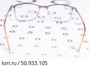 A pair of eyeglasses with a gold frame and a black lens. Стоковое фото, фотограф Скрипачев Антон / Фотобанк Лори