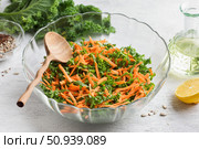 Salad with kale, carrots and seeds in a transparent salad bowl on a light gray background. Стоковое фото, фотограф Ольга Лепёшкина / Фотобанк Лори