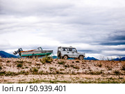 SUV car carrying fisherman boat in trailer, summer landscape view on cloudy day. Стоковое фото, фотограф Spirit River / Фотобанк Лори