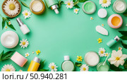 Wellness concept: Beauty product layout for promotional content, showcasing skin care creams and flowers on a green background. Стоковое AI-изображение, AI-художник Данила Большаков / Фотобанк Лори