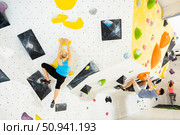 Woman and man alpinists practicing in pair indoor rock-climbing on climbing wall. Стоковое фото, фотограф Яков Филимонов / Фотобанк Лори