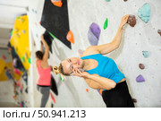 Woman having phone call during training in bouldering gym. Стоковое фото, фотограф Яков Филимонов / Фотобанк Лори