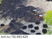 An aerial shows wheelbarrows, shovels, and piles of dark soil during land preparation. Concept of Groundwork development. Стоковое фото, фотограф Ольга Петрова-Апостолова / Фотобанк Лори