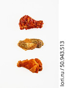 Three fried chicken wings in breading and different sauce on white background. Стоковое фото, фотограф Ирина Буракова / Фотобанк Лори