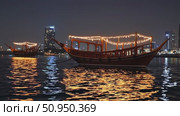 Wooden dhows illuminated with vibrant lights navigating Dubai Creek after sunset, silhouetted against glowing cityscape buildings and reflecting shimmering waters. Стоковое AI-видео, аниматор Данил Руденко / Фотобанк Лори