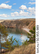 Lake Baikal in summer. People relax on the sandy beach of Olkhon Island, sunbathe and ride SUP boards in the shallow bay of the Small Sea on a sunny day in July. Active recreation in summer holidays. Стоковое фото, фотограф Виктория Катьянова / Фотобанк Лори