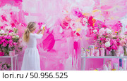 Woman creating an expressive mural on a vibrant pink wall, surrounded by blooming floral arrangements, symbolizing artistic passion and spring vibrancy. Стоковое AI-изображение, AI-художник Данила Большаков / Фотобанк Лори