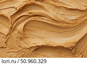 Creamy peanut butter spread swirl surface. Closeup, full frame. Crunchy Peanut butter background. American cuisine traditional product. Appetizing textured smears. Food paste from ground roasted nuts. Стоковое AI-изображение, AI-художник Марина Демидюк / Фотобанк Лори