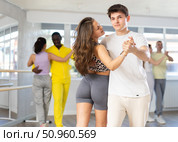 Young man and woman practicing waltz dance in pair in training hall. Стоковое фото, фотограф Яков Филимонов / Фотобанк Лори