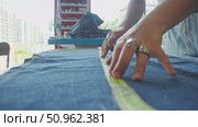 Using tape measure and chalk to mark precise lines on denim fabric. Стоковое видео, видеограф Strunov David / Фотобанк Лори
