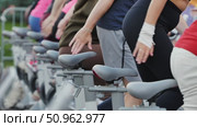 Athletes pedaling on exercise bikes during sports day. Стоковое видео, видеограф Mikhail Davidovich / Фотобанк Лори