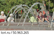 Water Fountain Streams with Park Visitors Relaxing Nearby. Стоковое видео, видеограф Mikhail Davidovich / Фотобанк Лори