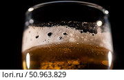 Close-up of fresh frothing light beer in a glass on a dark background. Стоковое фото, фотограф Михаил Решетников / Фотобанк Лори