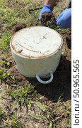 Upside-down pot on ground. Man installing mole trap into animal burrow. Covered with pot for light isolation. Vertical video. Стоковое видео, видеограф Vadzim Yakubovich / Фотобанк Лори