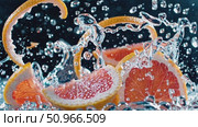 Grapefruit segments splashing, creating water droplets and bubbles against dark backdrop, highlighting citrus freshness and nutritional benefits. Стоковое AI-видео, аниматор Данил Руденко / Фотобанк Лори