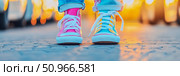 Vibrant mismatched sneakers on a pavement at golden hour, capturing a playful and youthful spirit for an outdoor adventure advertisement. Стоковое AI-изображение, AI-художник Данила Большаков / Фотобанк Лори