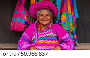 A warm portrait of an elder Indigenous woman showcasing vibrant traditional attire and colorful woven textiles, exuding wisdom and joy. Стоковое AI-изображение, AI-художник Данила Большаков / Фотобанк Лори