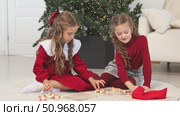 Little children girls play russian lotto board game at home on the Christmas tree background. Children early development. Christmas and New Year holidays time. Board game and kids leisure concept. Footage. Стоковое видео, видеограф Ирина Михайличенко / Фотобанк Лори
