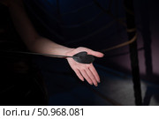 An unrecognizable woman demonstrates an elegant thin leather strip whip in a dark bedroom. Close-up of female hands with a bdsm toy. Pain and pleasure.Adult toy for slaps. Стоковое фото, фотограф Михаил Решетников / Фотобанк Лори
