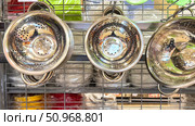 Three metal strainers are on a shelf. Russia. Moscow. 02.08.25. Редакционное фото, фотограф Ярославский Максим / Фотобанк Лори