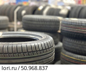 A pile of tires are stacked in a store. Редакционное фото, фотограф Ярославский Максим / Фотобанк Лори