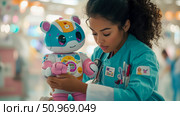 Dedicated healthcare professional tenderly interacts with a cheerful, child-friendly robot companion in a bright medical setting, showcasing the compassionate integration of AI in future patient care. Стоковое AI-изображение, AI-художник Данила Большаков / Фотобанк Лори